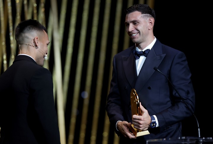 Dibu, recibiendo el premio de manos de Lautaro Martínez. (EFE)